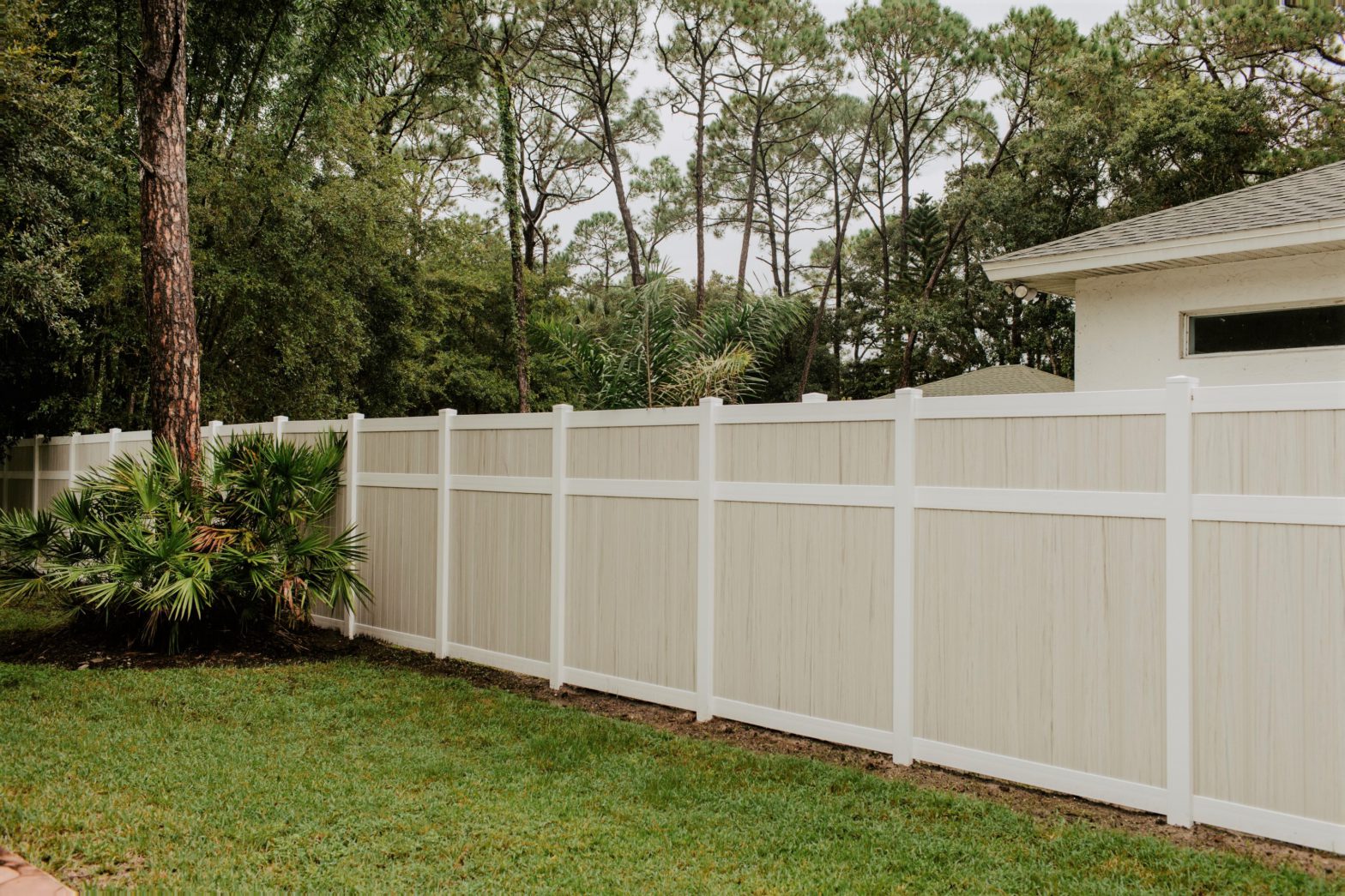 Photo of a vinyl fence that is tan and white